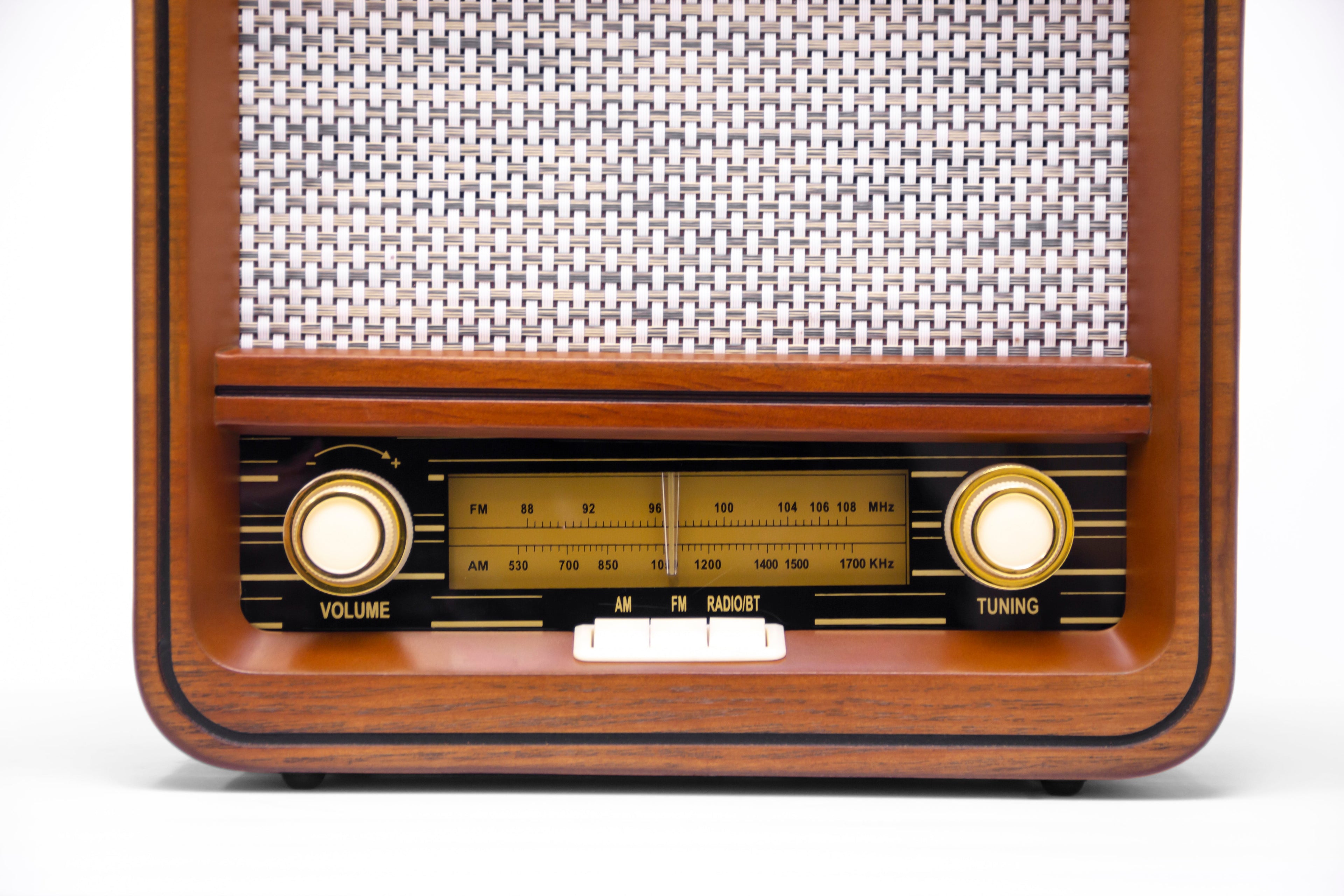 Wooden retro radio front with speaker grille and two large illuminated tuning knobs